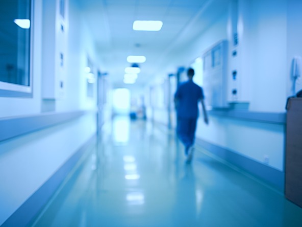 person walking down blurred hospital corridor